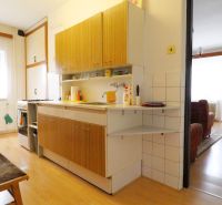 Kitchen and living room in a family house with a wooden decor floor.