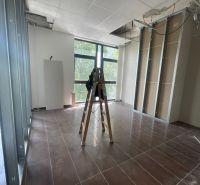 Offices with a ladder and an unfinished ceiling, floor with wood decor.