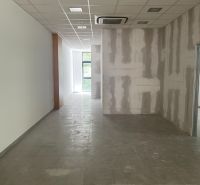 Offices with glass windows and tiled floors, ceiling with integrated air conditioning.