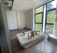 Offices with large windows, air conditioning, and clutter, with a wooden decor floor.