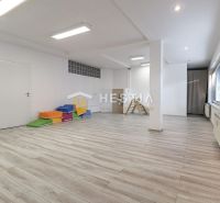 Commercial spaces with wood-patterned flooring, ceiling lighting, colorful mattresses, and windows.