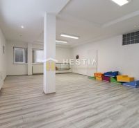 Spacious commercial spaces with wood-patterned flooring and colorful seating elements.