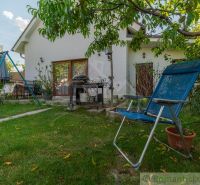 The garden of a family house in Bernolákovo with a swing, garden furniture, and greenery.