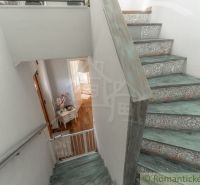 A staircase in a family house with decorative patterns and a floor with a wooden decor.