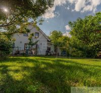 A family house in Bernolákovo surrounded by a garden with greenery and trees.