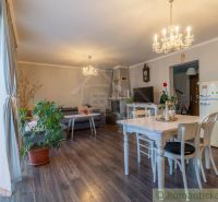 Interior of a family house with a wooden decor floor, dining table, and sofa set.
