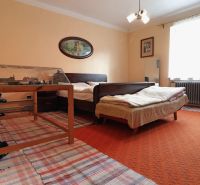A bedroom with a light orange carpet and a model railway in a family house.