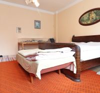 A bedroom with wooden furniture and a carpet in a family house.