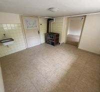 A kitchen in a family house with tiles and a sink, floor with wood decor.