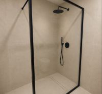 Shower enclosure with a black frame in a 4-room apartment. Clean lines and elegant design.