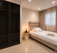 Bedroom in a 4-room apartment, simple bed, nightstand, and wardrobe.
