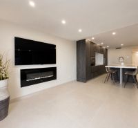 Living room in a 4-room apartment with a fireplace and a kitchenette, floor with wood decor.