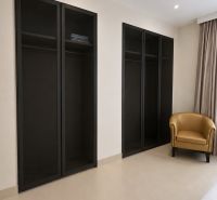 In the 4-room apartment, there is a black wardrobe and a beige armchair.