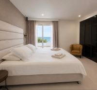 Bedroom in a 4-room apartment with a sea view, featuring a comfortable bed and a wardrobe.