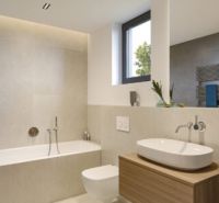 A bathroom in a family house with a freestanding bathtub and a sink on a wooden stand.