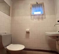 A bathroom in a family house with white tiles and a simple interior.