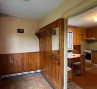 A kitchen in a family house with wooden paneling and equipment.