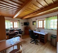 An office equipped with office furniture and two desks, with a wooden decor floor.