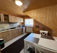 Hotel and guesthouse kitchen with wood-decor flooring and a dining table.