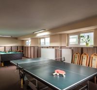 Ping pong and billiard table in the game room of hotels and guesthouses with wooden decor.
