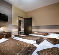 A room with a wooden floor decor, beds, and a television in a hotel and guesthouses.