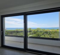 The large window in the 4-room apartment offers a panoramic view of nature and the sea.