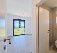 Interior of a 4-room apartment with light walls and tiles, modern windows and doors.