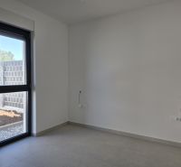 An empty room with a large window in a 4-room apartment, tiled floor.