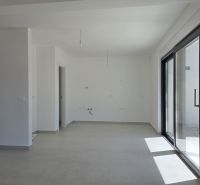 A spacious living area of a 4-room apartment with large windows and white walls.