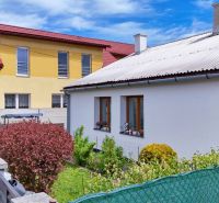 A family house in Košťany nad Turcom with a yard, fence, and natural greenery.