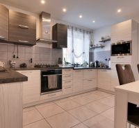A kitchen in a family house with modern appliances and a dining table.