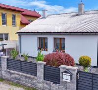 A family house in Košťany nad Turcom with a landscaped garden and a modern fence.