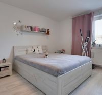 A bright bedroom in a family house with a wooden decor floor and exercise equipment.