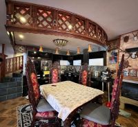 The kitchen of a family house with richly decorated chairs and decorative railing.