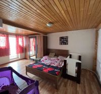 Bedroom in a family house with a crib, wooden decor flooring, wooden ceiling.