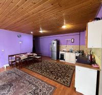 A kitchen in a family house with purple walls, a kitchen unit, and a dining table.