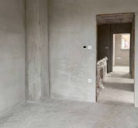 The interior of a family house with unfinished walls and a passage to another room.