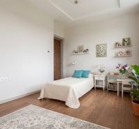 A room in a family house with a bed, decorations, and a wooden decor floor.