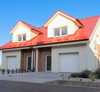 A family house in Andovce with a red roof and brick cladding.