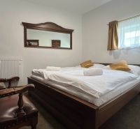 Interior of hotel and guesthouse rooms with a double bed and a mirror on the wall.