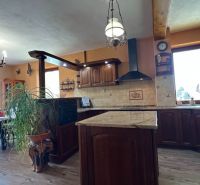 A kitchen with solid wood, a bar counter, and a floor with a wooden decor in hotels and guesthouses.
