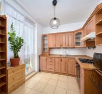 A kitchen in a 2-room apartment with a wooden decor kitchen unit and counter.