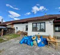 A family house in Horné Obdokovce with a supply of wood and waste in blue bags.