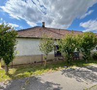 A family house in Horné Obdokovce with a white facade and a tiled roof, surrounded by greenery.
