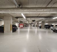 Underground garage with parking and lighting, several parked cars.