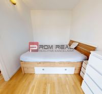 Bedroom in a 2-room apartment with a bed and a dresser, floor with wood decor.