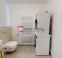 Bathroom of a 2-room apartment with a toilet, sink, and a washer with a dryer.