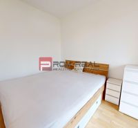 Bedroom with a bed and a dresser in a 2-room apartment, floor with wood decor.