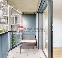 A balcony with rattan furniture next to the living room in a 2-room apartment.