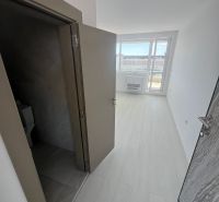 The hallway in the 2-room apartment shows a floor with a wooden decor and a view of the terrace.
